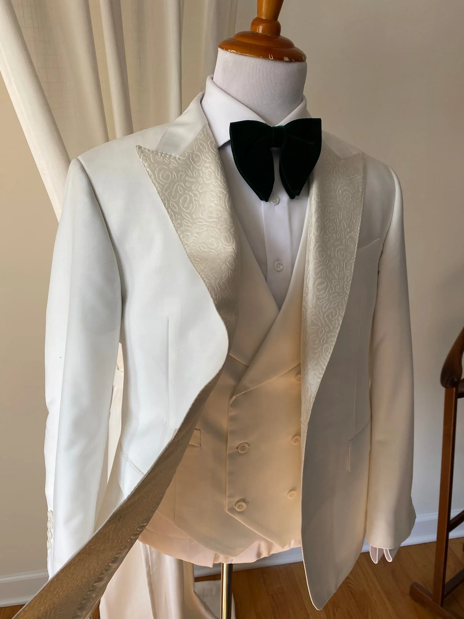Ivory tuxedo jacket with satin shawl lapel on a tailor's form