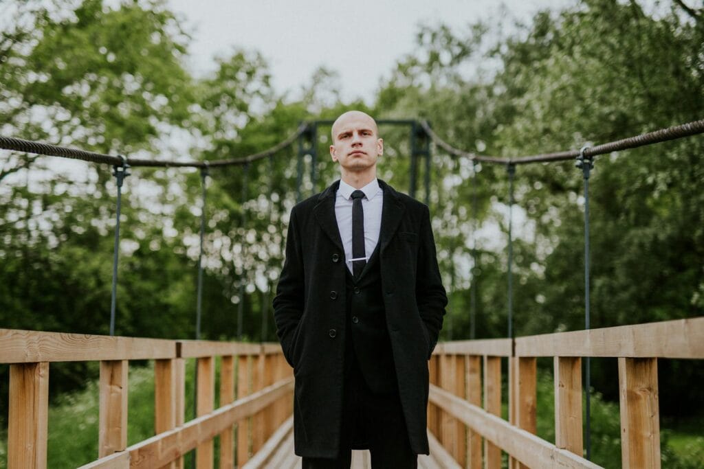 Bald Man in Coat on Bridge