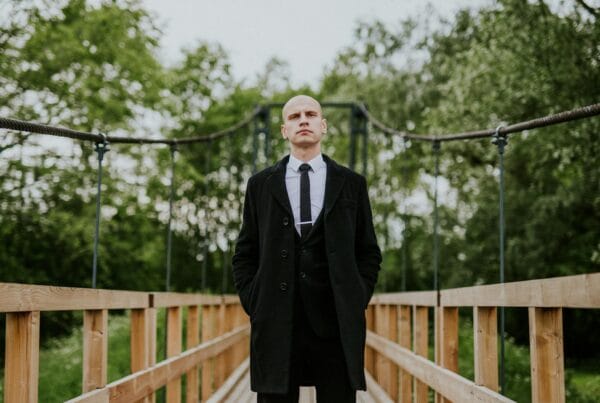 Bald Man in Coat on Bridge