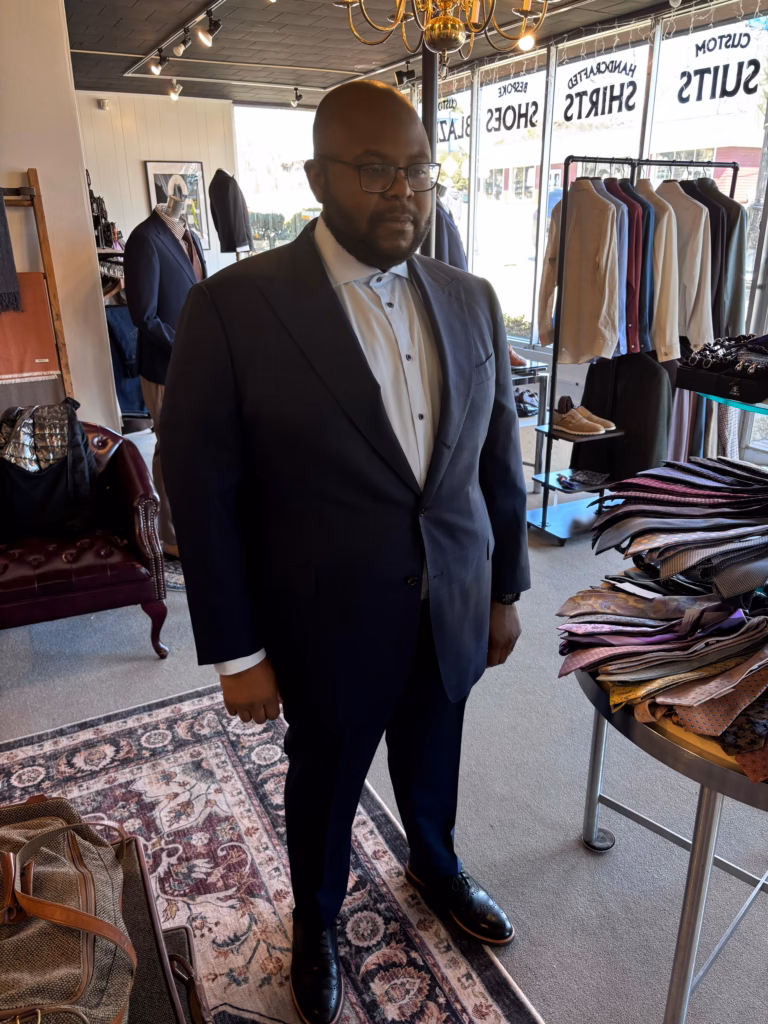 WhatsApp Image 2026-03-23 at 21.23.23 (1) client standing in tailoring studio during fitting process wearing navy bespoke suit