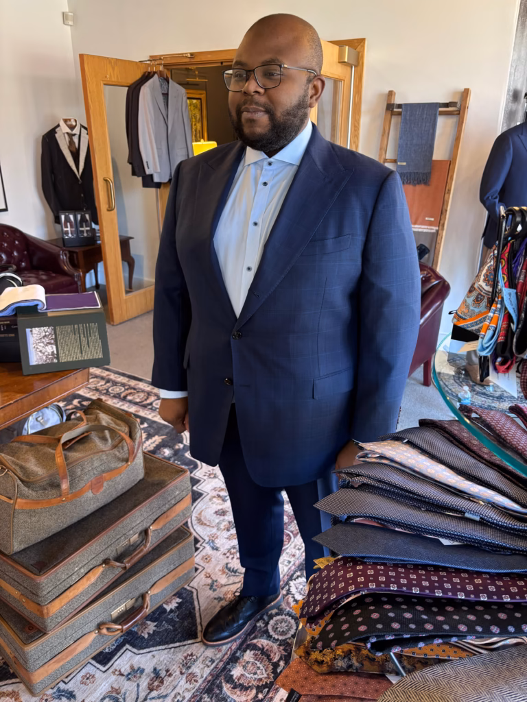 WhatsApp Image 2026-03-23 at 21.23.23 (2) client standing in tailoring studio during fitting process wearing navy bespoke suit