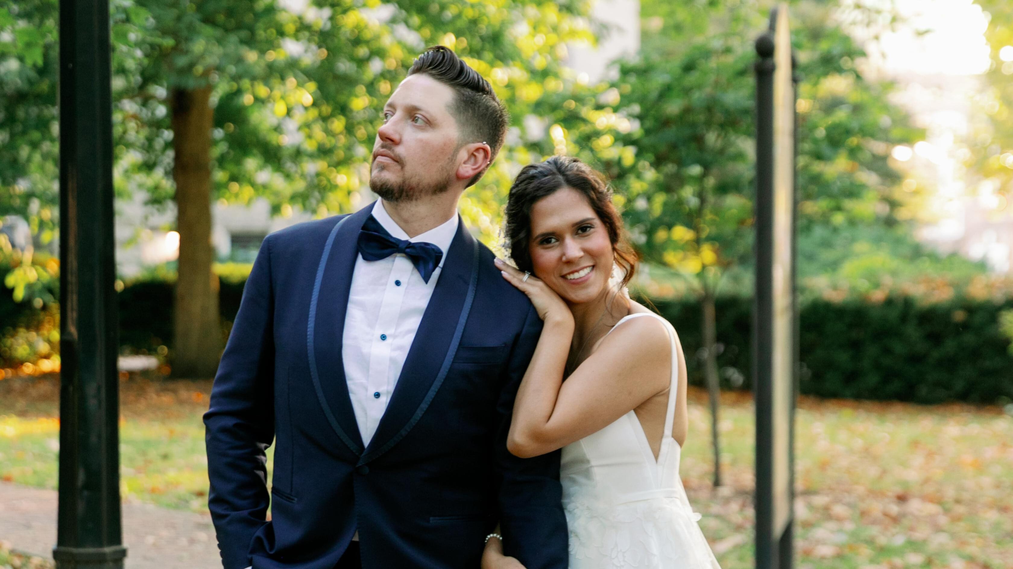 groom in bespoke wedding tuxedo with bride posing outdoors
