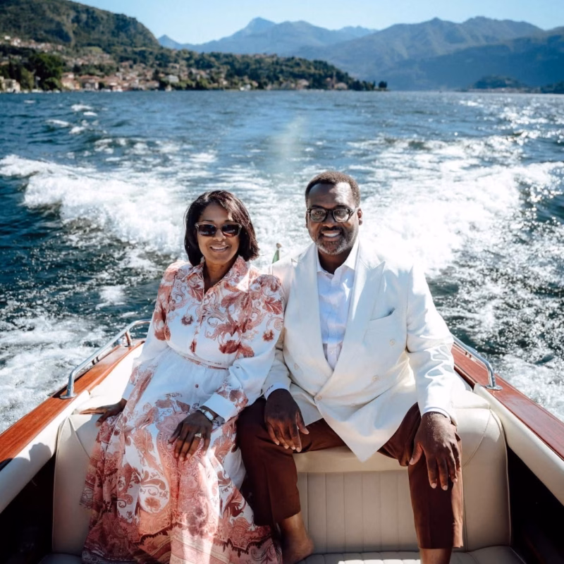 Najuan Brown wearing a custom white double-breasted suit by The Tailored Foundation while riding on a boat with his wife in Lake Como, Italy.